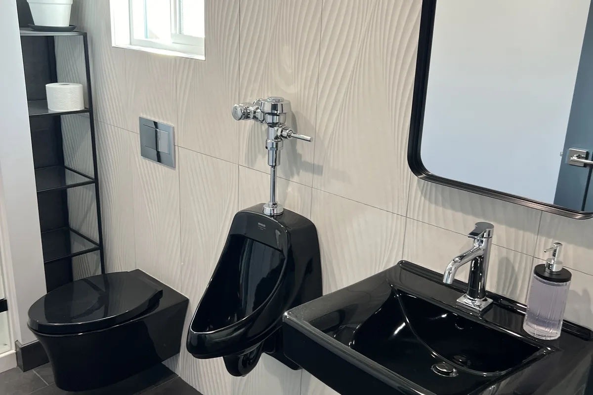 Finished commercial restroom with code-compliant fixtures installed by DAE Plumbing.