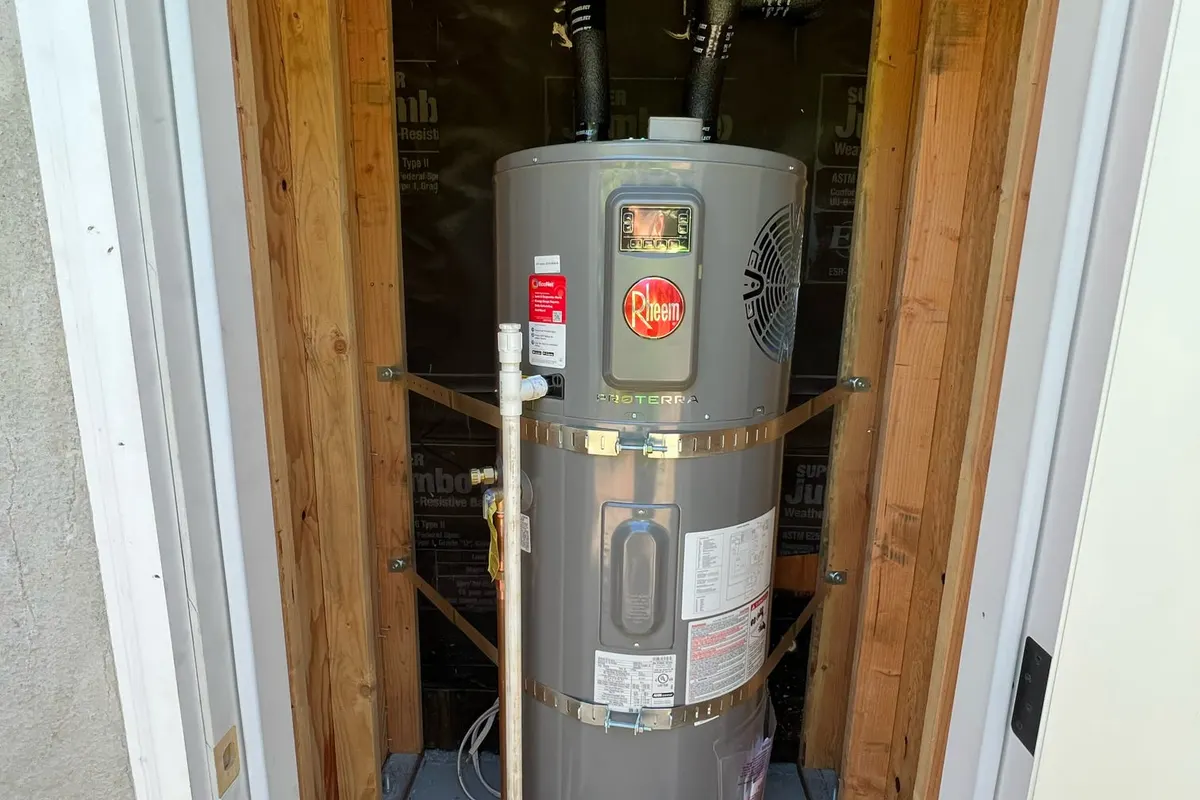 New Rheem water heater set in a closet with seismic strapping and relief piping.
